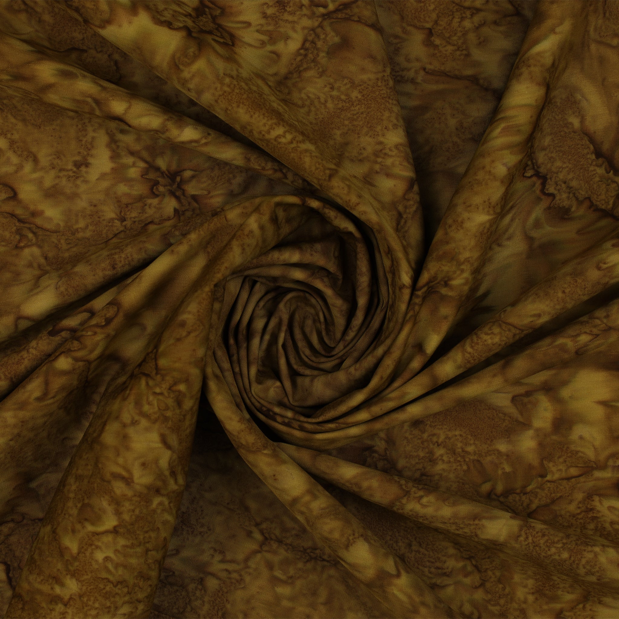 Brown and tan batik fabric draped in a spiral swirl pattern, showing a mottled organic print.