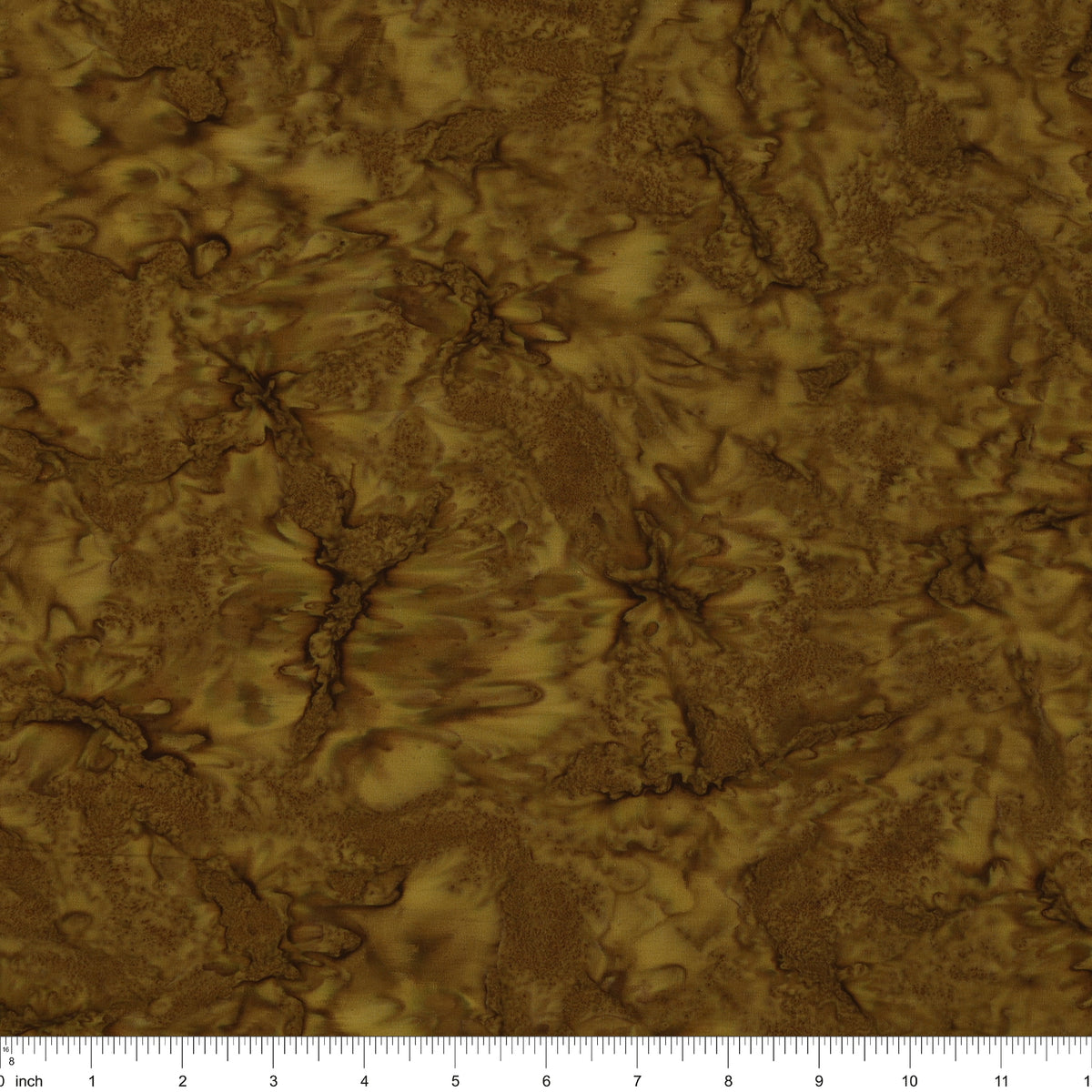 A close-up of a brown and gold marbled fabric with a ruler scale along the bottom edge.