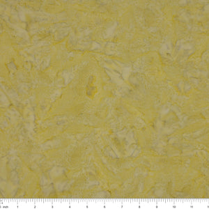 A close-up of a textured fabric in pale yellow with irregular white marbled patterns, with a ruler scale visible along the bottom edge.