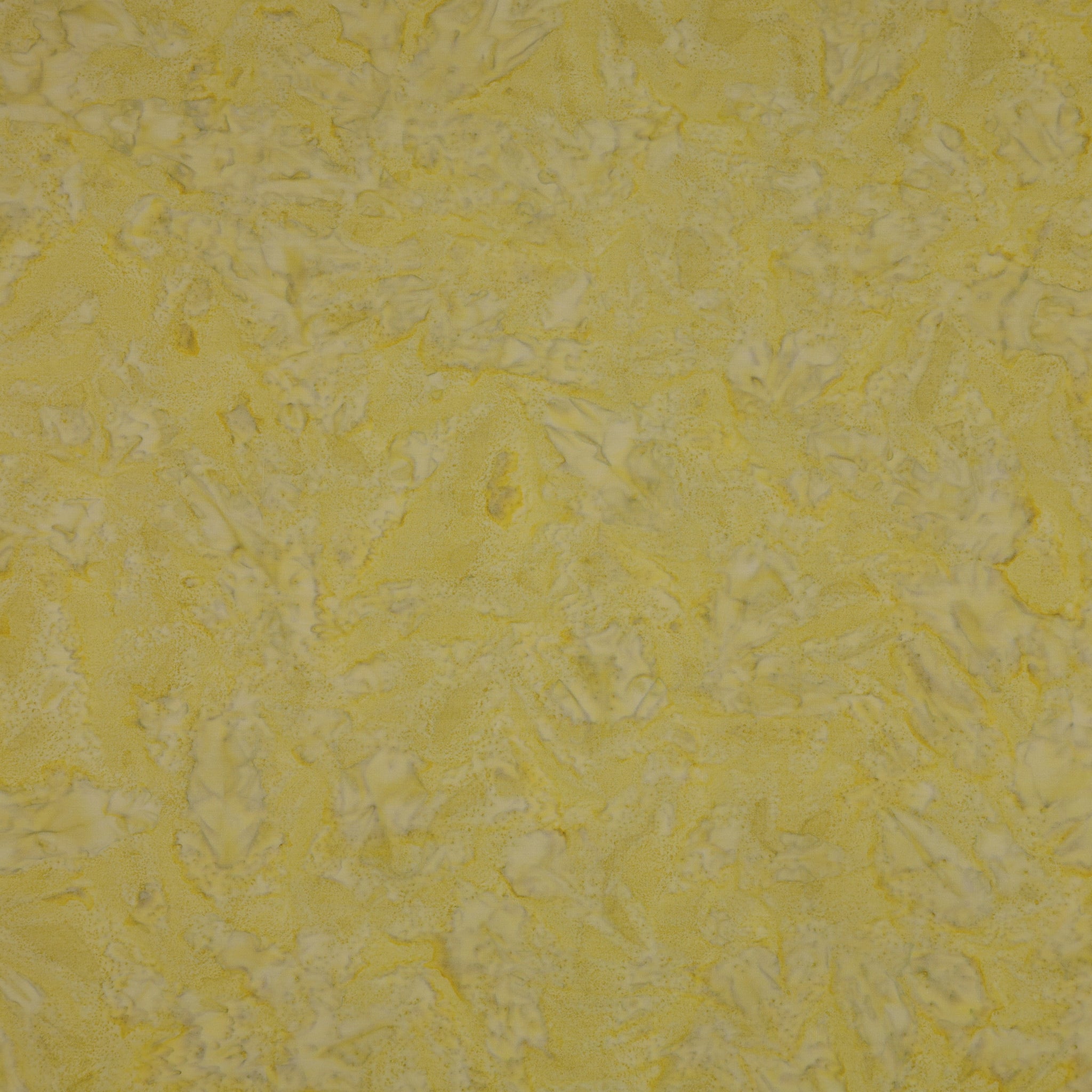A close-up of a textured yellow fabric showing a mottled pattern.