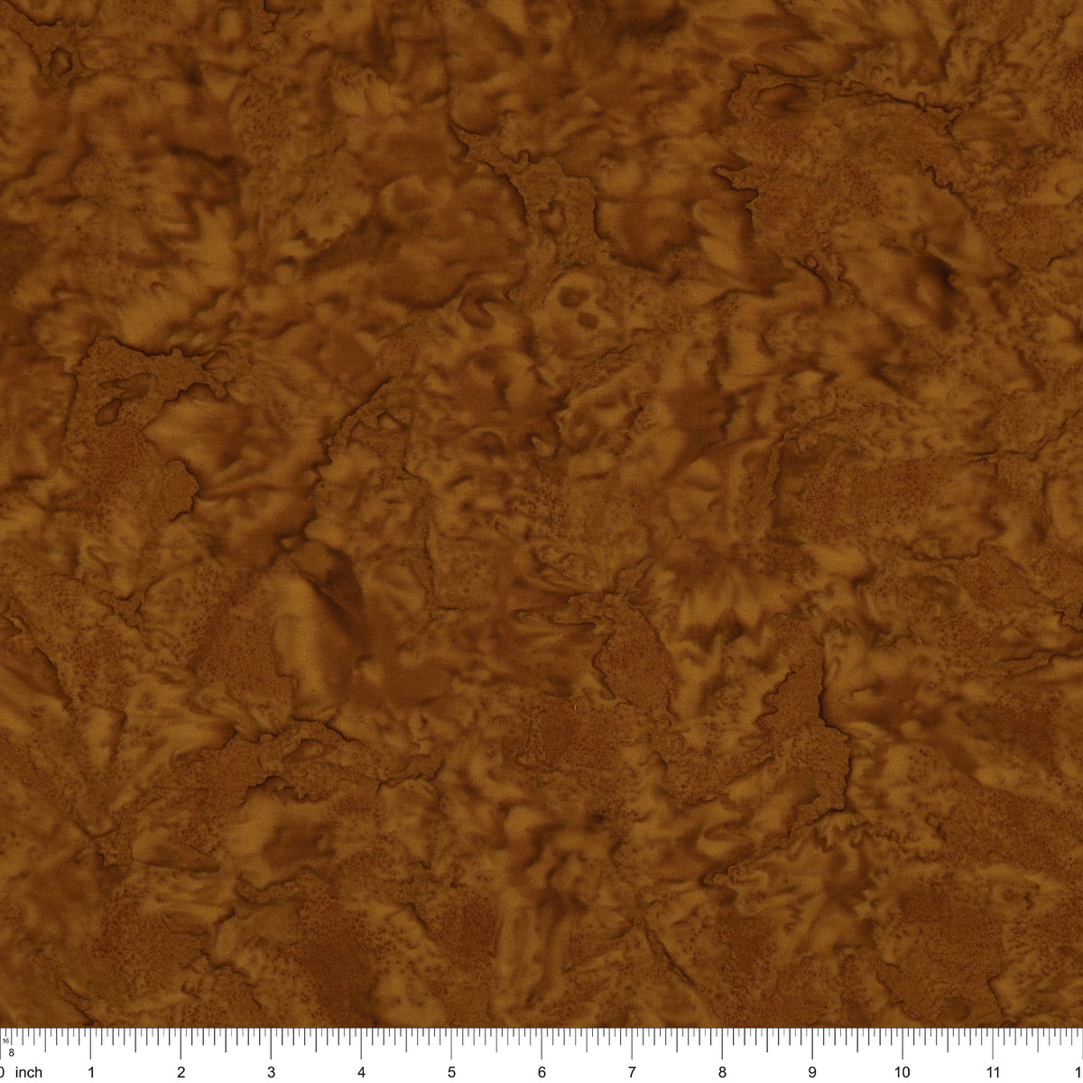 A close-up of a brown textured material with an organic, cracked or leaf-like surface pattern, shown with a ruler along the bottom edge for scale.