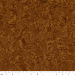 A close-up of a brown textured material with an organic, cracked or leaf-like surface pattern, shown with a ruler along the bottom edge for scale.