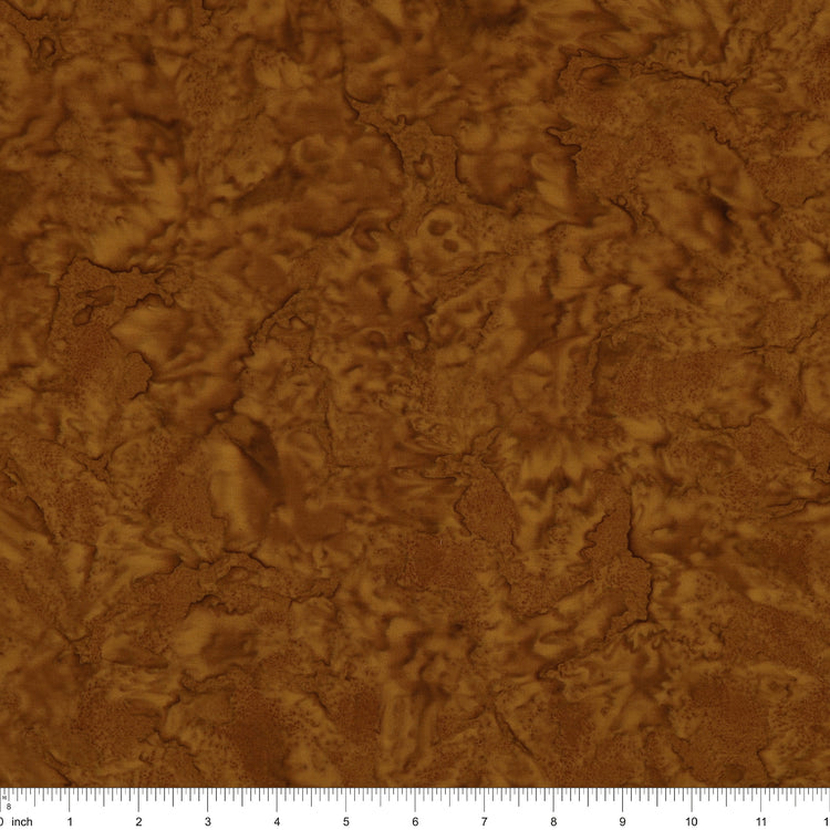 A close-up of a brown textured material with an organic, cracked or leaf-like surface pattern, shown with a ruler along the bottom edge for scale.