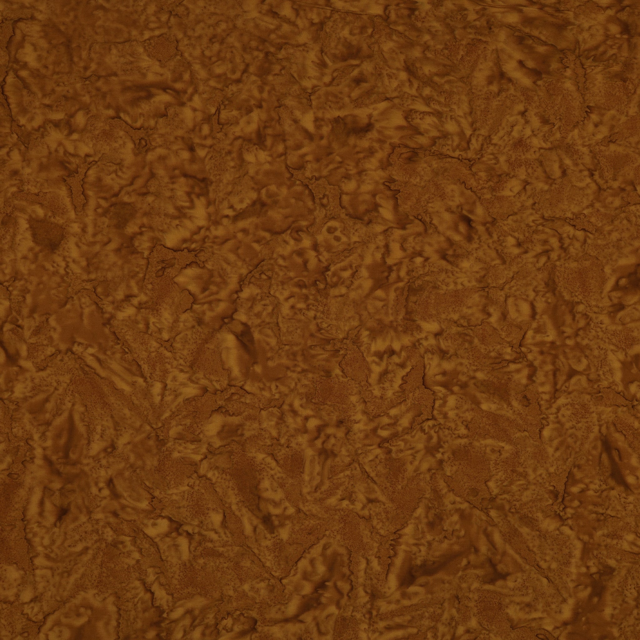 A close-up of a brown textured material with a mottled, organic surface pattern.