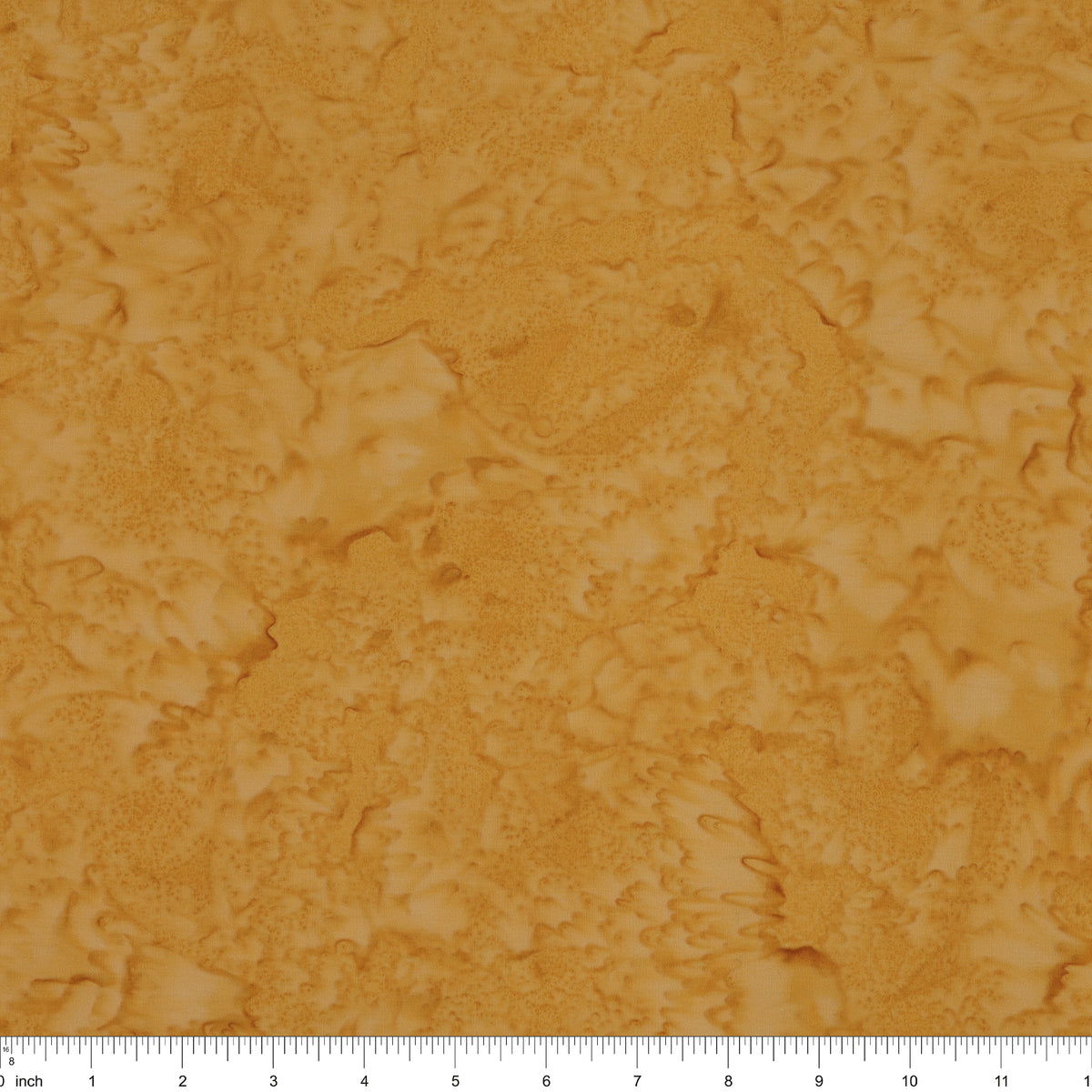 A close-up of a mottled golden-brown fabric with a ruler scale visible along the bottom edge.