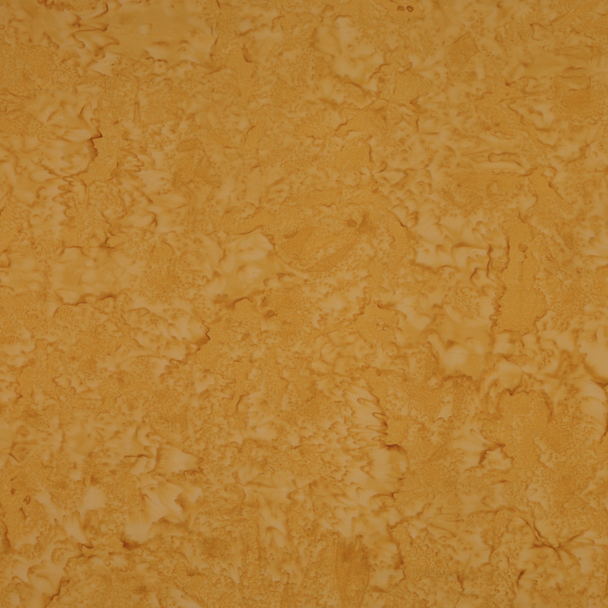 A close-up of a textured, mottled surface in warm golden yellow and orange-brown tones, filling the entire frame.