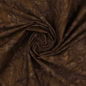 Brown batik fabric with a mottled organic pattern, draped in a spiral swirl to show its texture and drape.