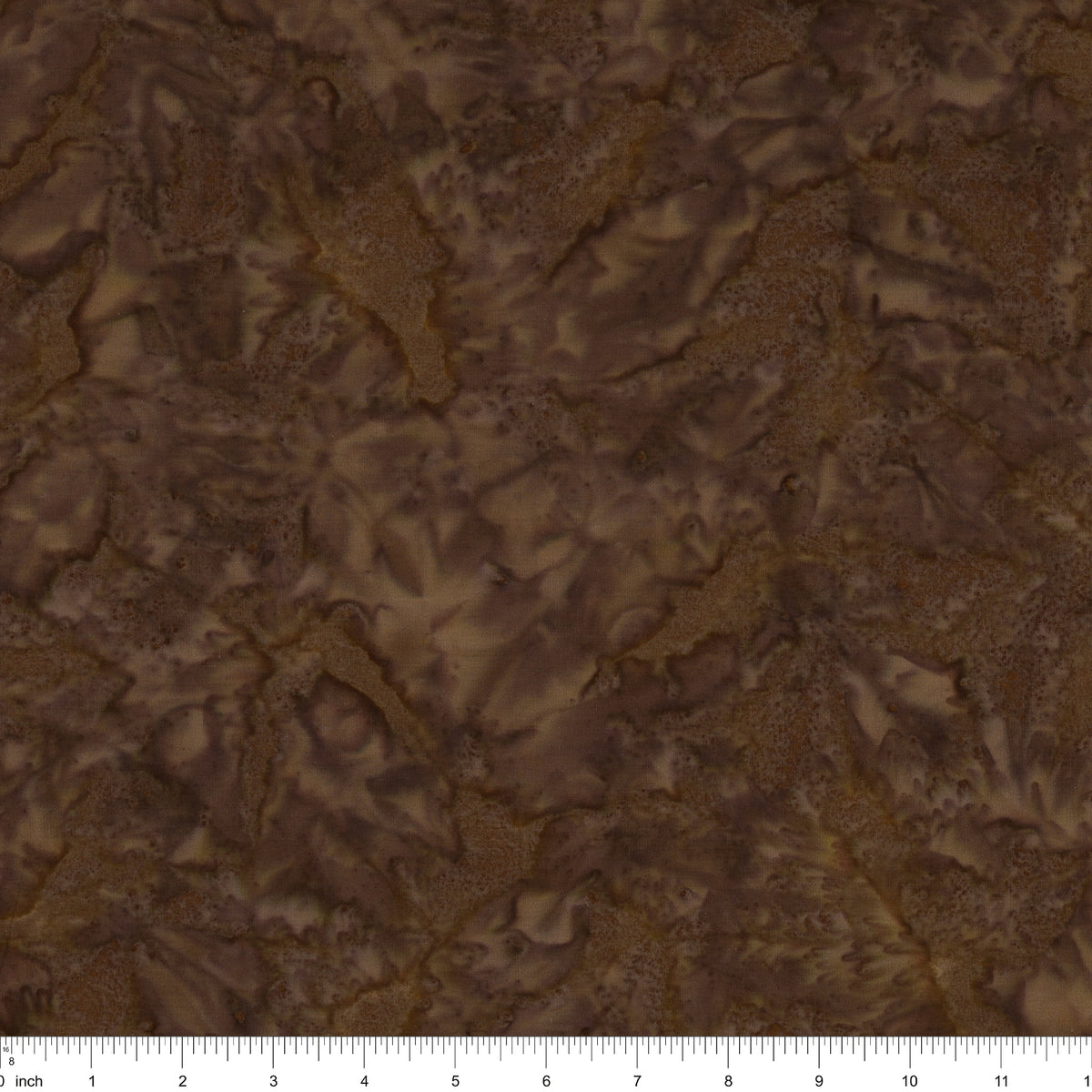 Brown batik fabric with a mottled, marbled pattern in shades of dark and light brown, featuring a 12-inch fabric ruler along the bottom edge.