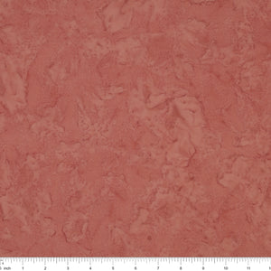 A close-up of a dusty rose surface with a white ruler along the bottom edge for scale.