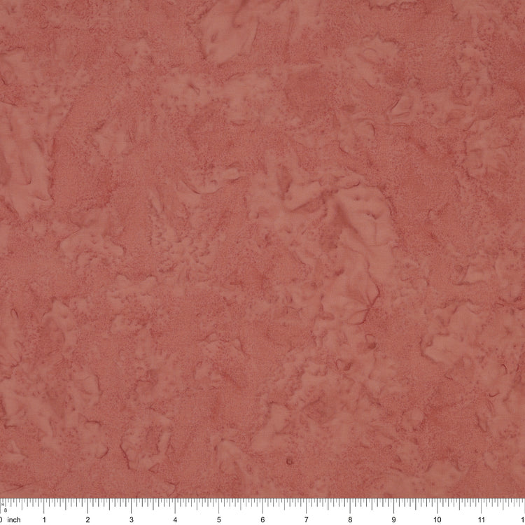 A close-up of a dusty rose surface with a white ruler along the bottom edge for scale.