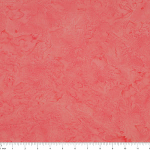 A close-up of a textured coral pink fabric with a subtle mottled or marbled pattern, featuring a white ruler scale at the bottom edge.