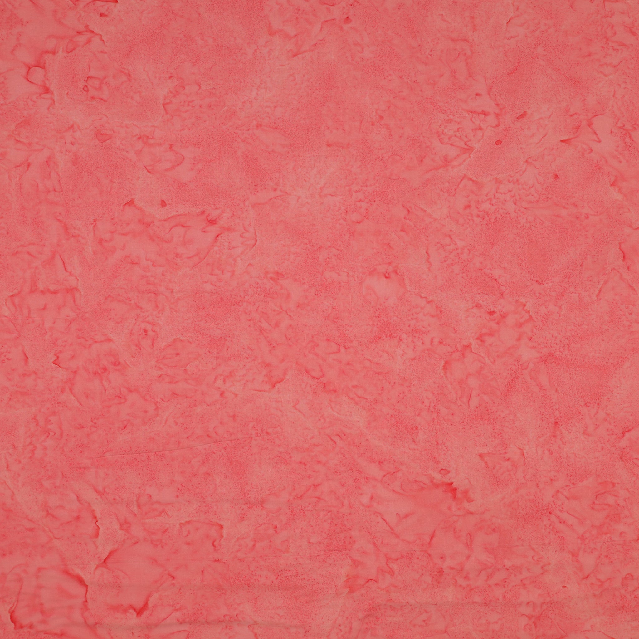 A close-up of a textured coral pink fabric filling the entire frame.