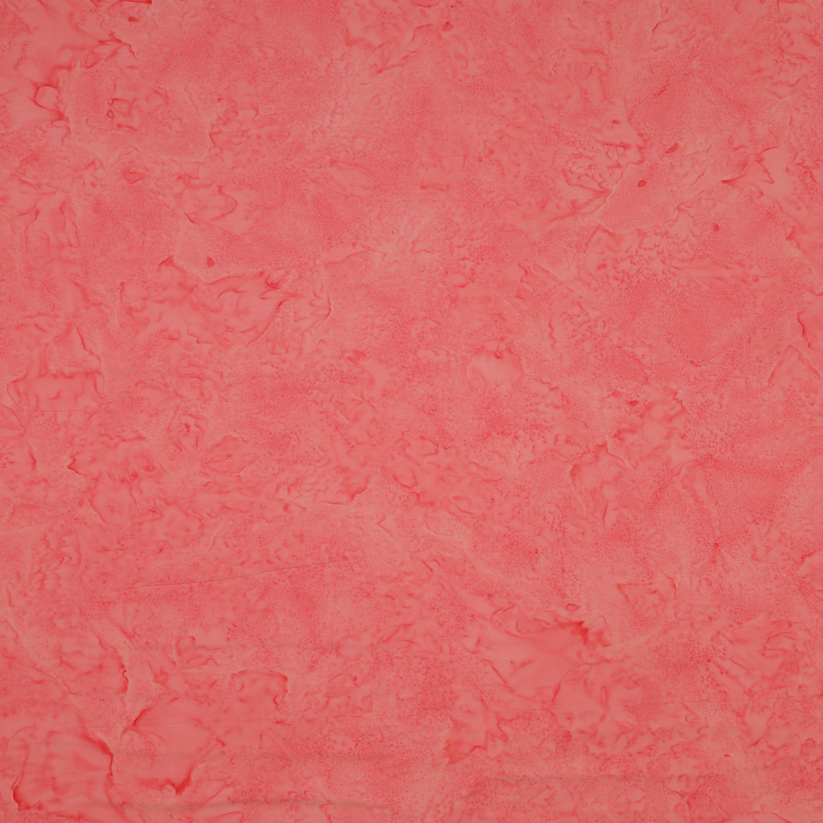 A close-up of a textured coral pink fabric filling the entire frame.