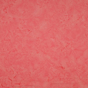 A close-up of a textured coral pink fabric filling the entire frame.