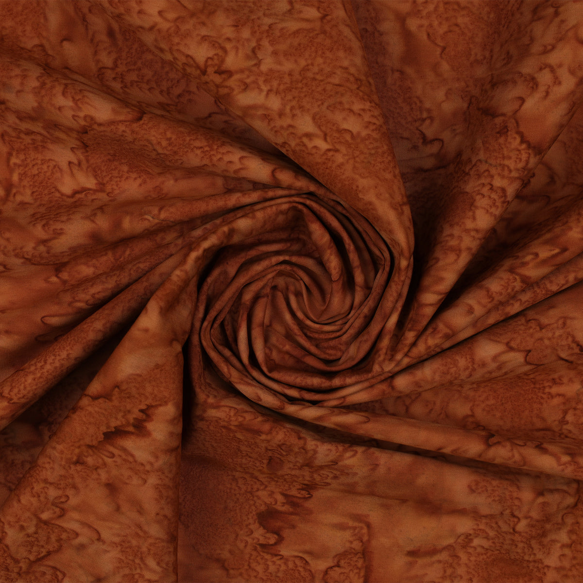 Brown batik fabric with a mottled abstract pattern, arranged in a spiral drape to show texture and color variation.