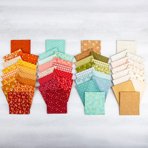 A collection of folded fabric swatches arranged in four vertical groups on a light gray wood background. The fabrics feature various patterns including florals, stripes, polka dots, and plaid in a wide range of colors including orange, yellow, red, pink, green, blue, and beige.