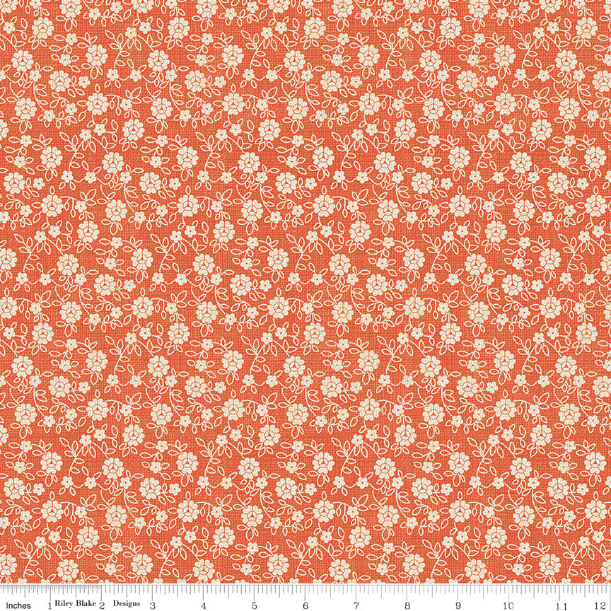 Floral pattern fabric swatch on an orange background with a ruler along the bottom for scale. 