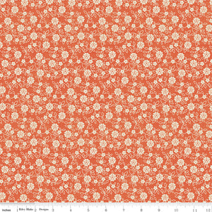 Floral pattern fabric swatch on an orange background with a ruler along the bottom for scale. 