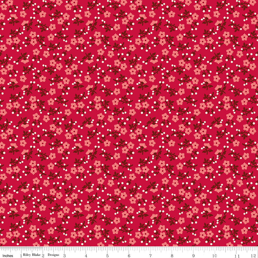 A repeating floral pattern on a bright pink background, featuring small peach flowers, dark red leaves, and scattered white dots. Ruler along the bottom for scale. 