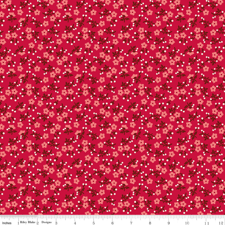 A repeating floral pattern on a bright pink background, featuring small peach flowers, dark red leaves, and scattered white dots. Ruler along the bottom for scale. 