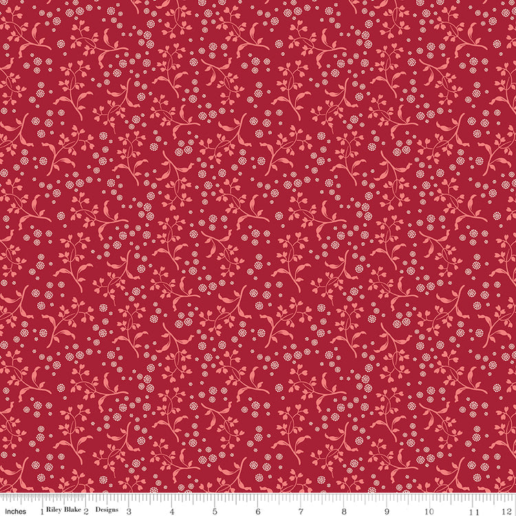 A repeating floral pattern featuring light pink vines and small white blossoms on a deep red background. Ruler along the bottom for scale. 