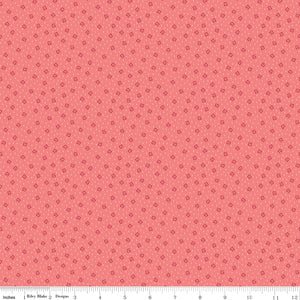 A repeating pattern of small dark red outlined diamonds on a coral pink background. Ruler along the bottom for scale.