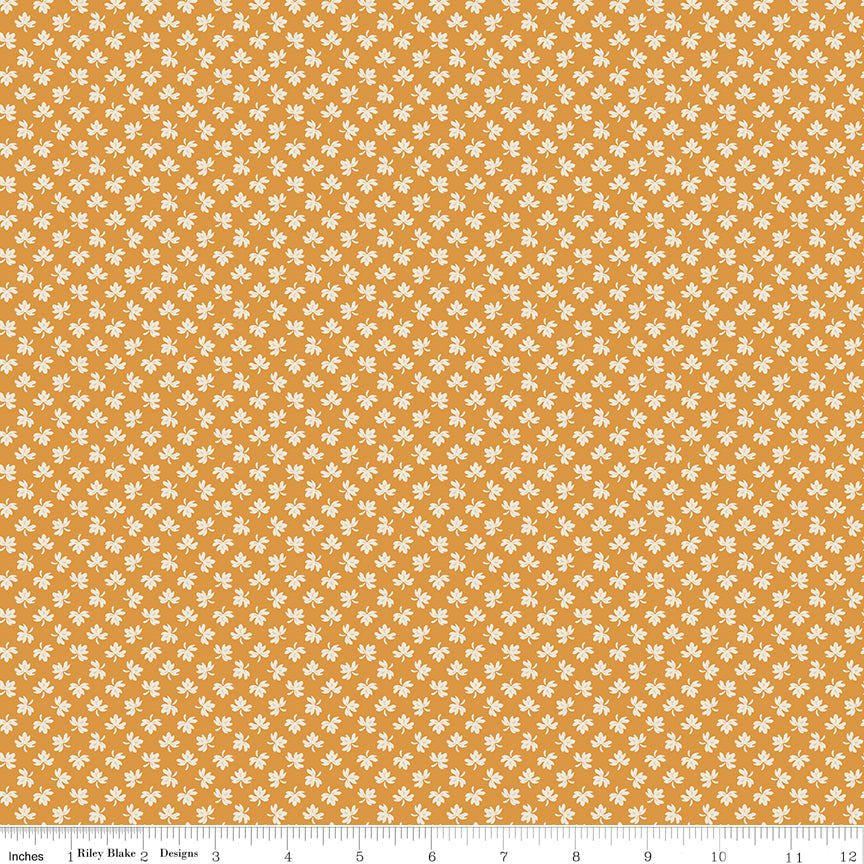 A repeating pattern of small white and muted gold plus signs on a dusty pink background, with a ruler along the bottom edge showing scale. 