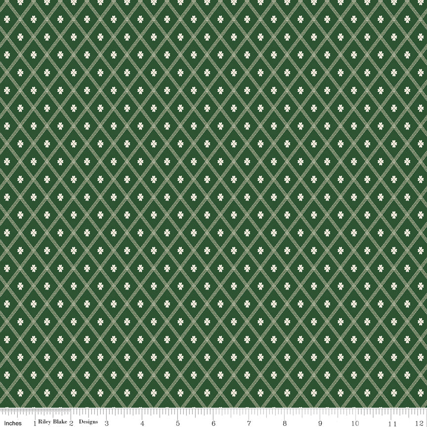 Northanger Abbey Thorpe Green fabric with cream diamond lattice and tiny flowers on deep green with ruler for scale.