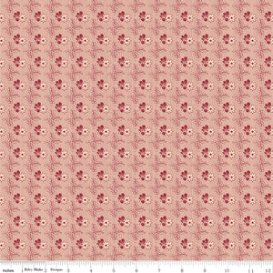 Northanger Abbey Richard fabric with small red floral motifs in a delicate repeat on pale peach with ruler for scale.