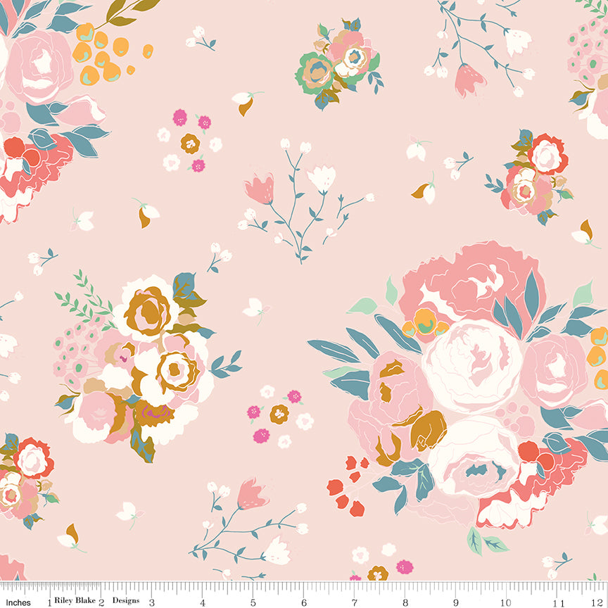 Cotton Nook Main Blush fabric with large colorful floral bouquets on a soft pink background with ruler for scale.