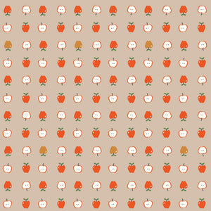 Cotton Nook Apples Biscuit fabric with red apples and sliced apples on a warm beige background.