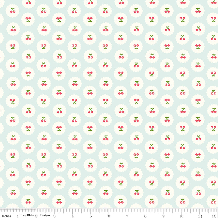 Cotton Nook Cherries Bleached Denim fabric with tiny cherries in white scalloped circles with ruler for scale.