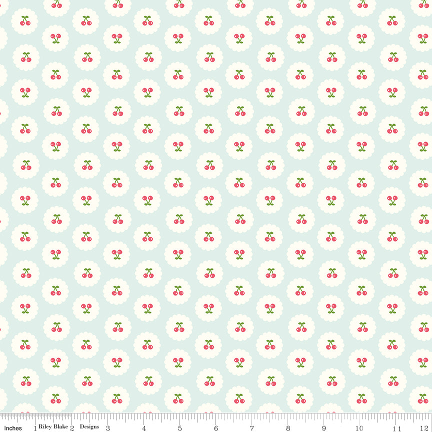 Cotton Nook Cherries Bleached Denim fabric with tiny cherries in white scalloped circles with ruler for scale.