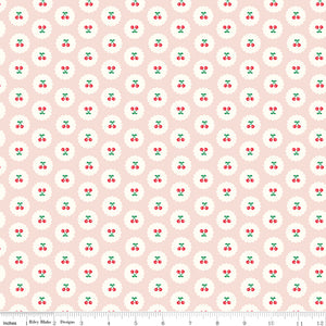 Cotton Nook Cherries Blush fabric with red cherries inside white scalloped circles on pale pink with ruler for scale.