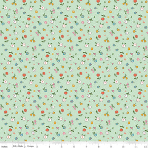 Cotton Nook Pretty Mint fabric with scattered colorful petite flowers on a soft mint green background with ruler for scale.