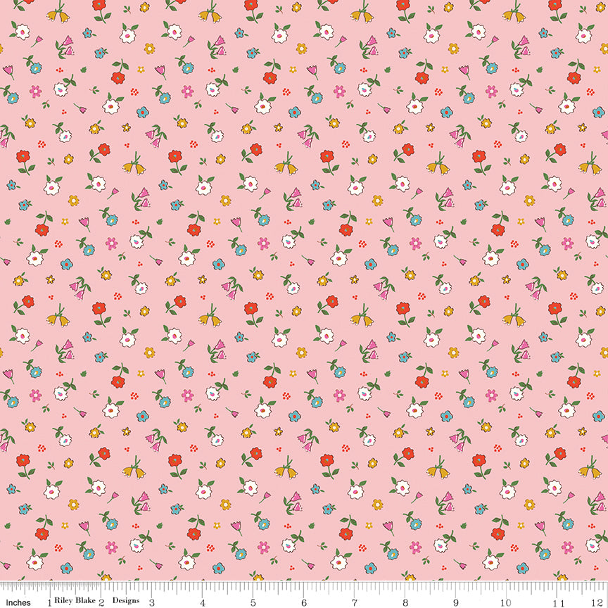 Cotton Nook Pretty Pink fabric with tiny colorful flowers and leafy sprigs on a soft pink background with ruler for scale.