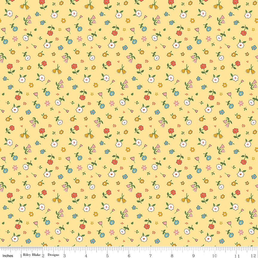 Cotton Nook Pretty Sunshine fabric with petite multicolor flowers on a warm yellow background with ruler for scale.