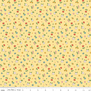 Cotton Nook Pretty Sunshine fabric with petite multicolor flowers on a warm yellow background with ruler for scale.