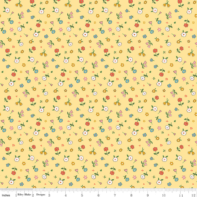Cotton Nook Pretty Sunshine fabric with petite multicolor flowers on a warm yellow background with ruler for scale.