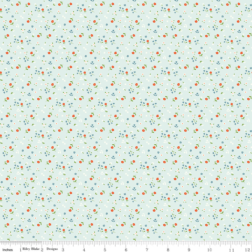Cotton Nook Flowers Bleached Denim fabric with tiny floral sprigs on a pale blue background with ruler for scale.