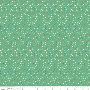 Cotton Nook Flowers Green fabric with tiny white, coral and blue flowers on a green background with ruler for scale.