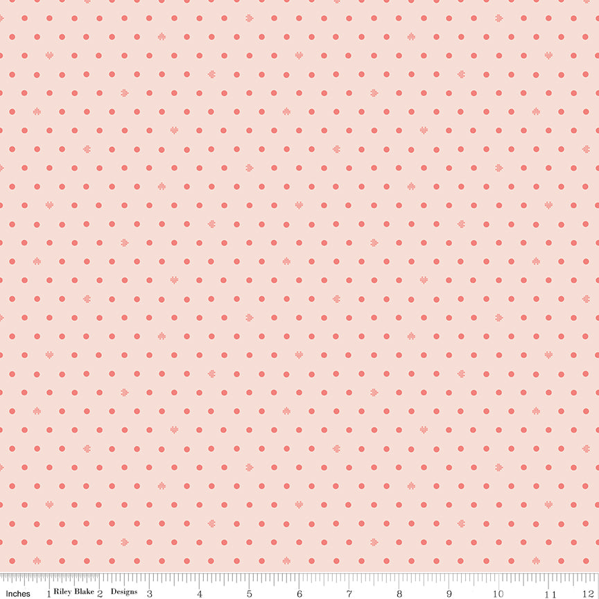 Cotton Nook Dots Blush fabric with small coral dots scattered across a pale blush background with ruler for scale.