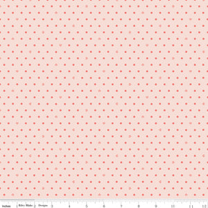 Cotton Nook Dots Blush fabric with small coral dots scattered across a pale blush background with ruler for scale.