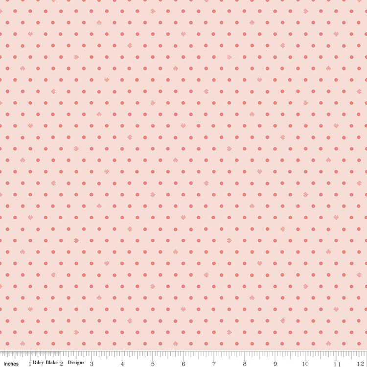 Cotton Nook Dots Blush fabric with small coral dots scattered across a pale blush background with ruler for scale.