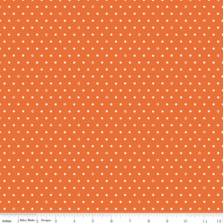 Cotton Nook Dots Orange fabric with small cream dots scattered across a bright orange background with ruler for scale.