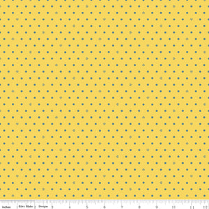 Cotton Nook Dots Yellow fabric with small blue-gray dots scattered across a sunny yellow background with ruler for scale.