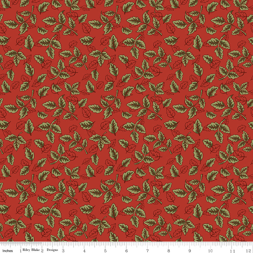 Red fabric with scattered olive green leafy sprigs and a ruler for scale