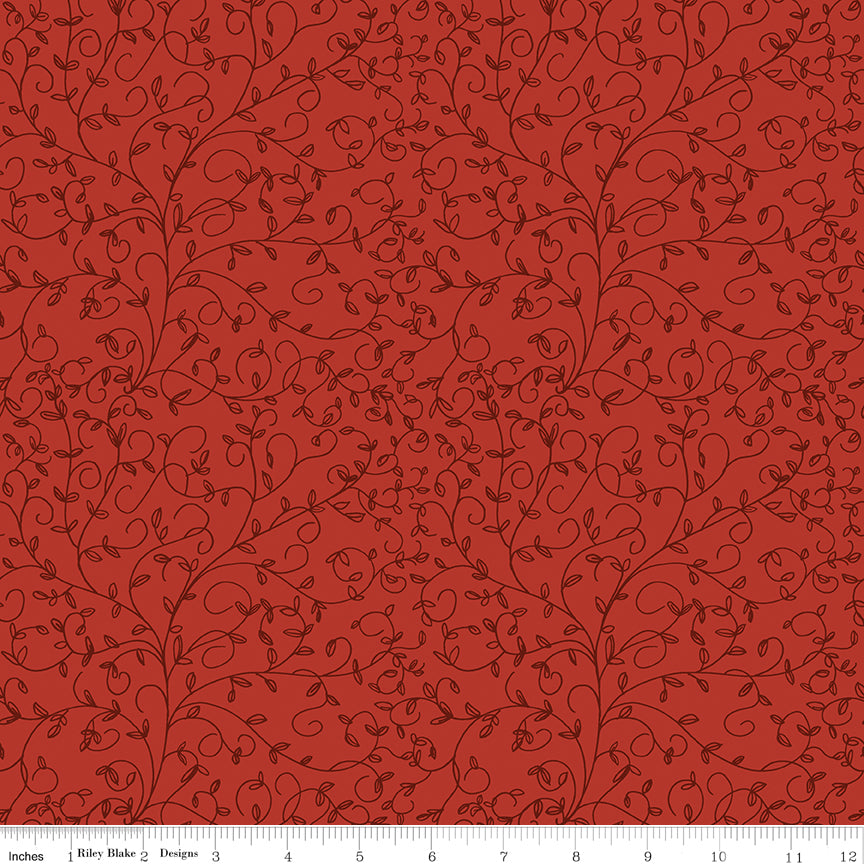 Red fabric with dark tonal curling vines and tiny leaves and a ruler along the bottom for scale.