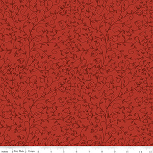 Red fabric with dark tonal curling vines and tiny leaves and a ruler along the bottom for scale.