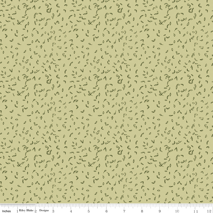 Celery green fabric with scattered tiny dark green leaf motifs with a ruler for scale along the bottom. 